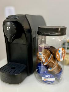 a toaster with a glass jar filled with packets at Apartamento Aconchegante Nogueira in Petrópolis