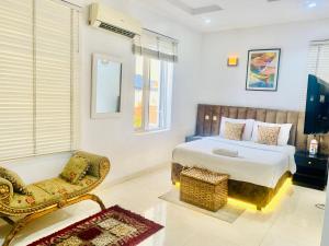 a bedroom with a king sized bed and a chair at 3Apartments in Lagos