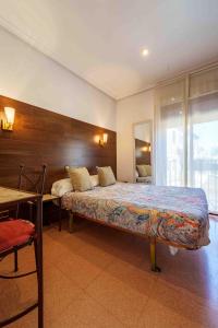 Un dormitorio con una cama, una mesa y un espejo. en Hostal Sol, en Toledo