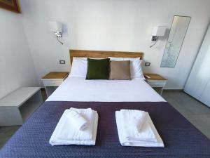 una camera da letto con un letto con due asciugamani sopra di Casa delle zie Savoretti a San Clemente