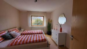 a bedroom with a bed and a mirror and a window at Casa Bölts in Heltersberg