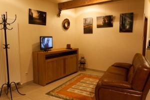 uma sala de estar com um sofá e uma televisão em Cleensyde em Horebeke