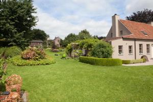 un patio de una casa con césped verde en Cleensyde, en Horebeke