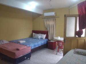 a hotel room with two beds and a table and a chair at San Miguel Hostal in Villarrica
