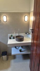 a bathroom with a sink with two lights above it at Pousada Green House Paraty in Paraty