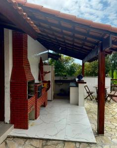 a patio with a brick fireplace and an outdoor kitchen at Pousada Green House Paraty in Paraty