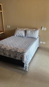 a bed with a comforter and a pillow in a room at Pousada Green House Paraty in Paraty