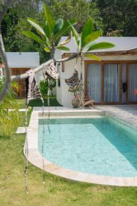 a swimming pool in front of a house at Promo - Private 1BR villa for couples in Kuta Lombok