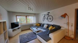 a living room with a couch and a bike on the wall at Casa Bölts in Heltersberg