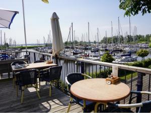 a balcony with tables and chairs and a marina at Hoeve Herweijer in Strijensas