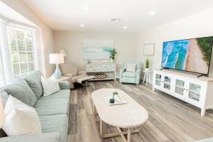 a living room with a couch and a tv at Oleander Drive - Coquina Sands in Naples