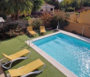 a swimming pool with two lawn chairs and a pair oficans at Next to the sea 20' from Barcelona in Premiá de Mar