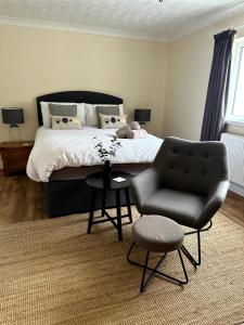 a bedroom with a bed and a chair at Ivy Cottage in Swansea