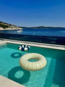 een zwembad met een vlot in het water bij Villa Venetta beach house ,Island Žirje, Šibenik in Muna