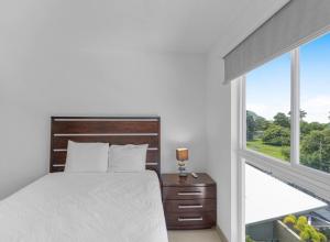 a white bedroom with a bed and a window at Jacó Pacífico in Jacó +19 photos