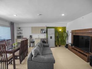 a living room with a couch and a table and a kitchen at Jacó Pacífico in Jacó