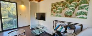 a living room with a cactus painting on the wall at Villa Lucitello by Monarca Location, refuge Familial à 10 minutes de Saint Florent in Barbaggio
