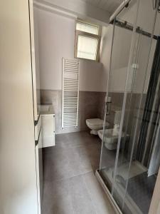 a bathroom with a glass shower and a toilet at Riverwell in Sesto Calende +8 photos