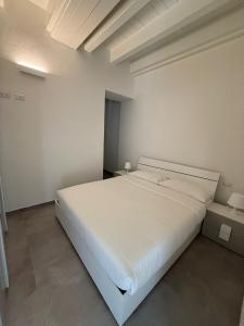 a large white bed in a white room at Riverwell in Sesto Calende
