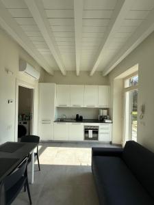a kitchen with white cabinets and a couch in a room at Riverwell in Sesto Calende
