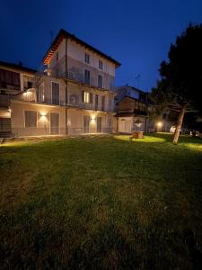 a large building at night with a large yard at Riverwell in Sesto Calende