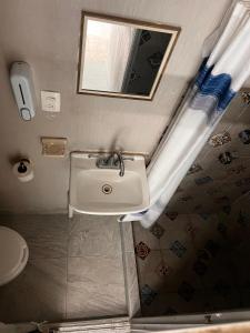 a bathroom with a sink and a mirror and a toilet at Nómadas Hostel in La Paz