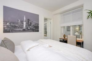 una camera da letto bianca con un letto grande e una scrivania di Tallinn Old Hanza Apartments a Tallinn