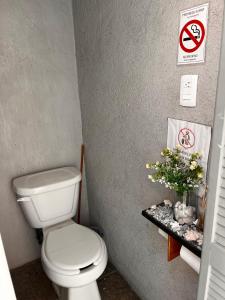 a bathroom with a toilet and signs on the wall at Nómadas Hostel in La Paz +36 photos