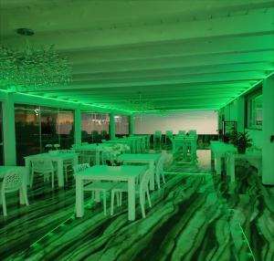a dining room with white tables and white chairs at Hotel Ohana in Rome