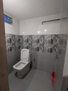 a bathroom with a white toilet in a stall at SriShivaShankari GuestHouse in Hyderabad