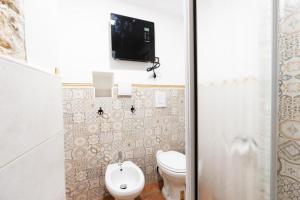 ein Bad mit WC und ein TV an der Wand in der Unterkunft Civico 11 in Molfetta + 12 Fotos
