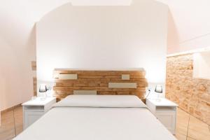 ein Schlafzimmer mit einem großen weißen Bett mit zwei Nachttischen in der Unterkunft Civico 11 in Molfetta