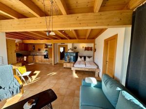 a living room with a blue couch and a kitchen at Gipfelruhe Ramsau am Dachstein in Ramsau am Dachstein