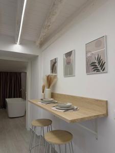 a kitchen with two stools and a table with plates at Seraphia Apartment in Palermo