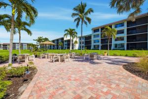 un patio con tavoli e sedie di fronte a un edificio di Loggerhead Cay 451 a Sanibel