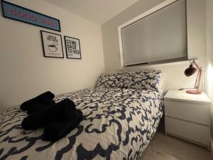 a bedroom with a bed with black and white sheets at Cosy Modern 2 Beds Chorley Center in Chorley
