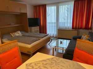 een woonkamer met een bed, een bank en een tafel bij Ferienwohnung mit Schwimmbad Ruheoase in Sankt Englmar