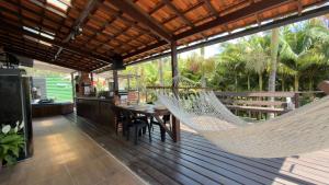 a hammock on a deck with a table and chairs at Casa com hidro privativa e área gourmet próximo ao Centro in Nova Friburgo