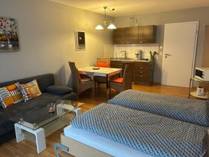 een woonkamer met een bank en een tafel en een keuken bij Ferienwohnung mit Schwimmbad Ruheoase in Sankt Englmar