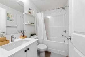 a white bathroom with a sink and a toilet at Cozy 2-Bed 1 Bath Entire Place in Calgary