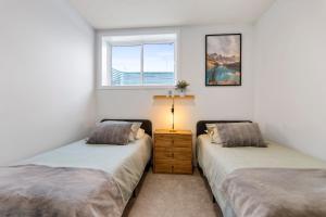 two beds in a room with a window at Cozy 2-Bed 1 Bath Entire Place in Calgary