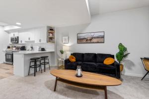 a living room with a black couch and a table at Cozy 2-Bed 1 Bath Entire Place in Calgary +8 photos