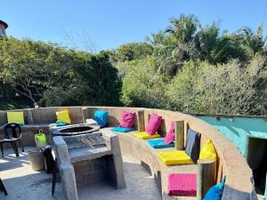 a wooden bench with colorful pillows on a patio at Swell Eco Lodge in Lutsheni