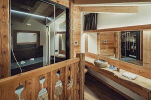 un bagno in una baita di tronchi con lavandino e specchi di Hotel Ciasa Lorenzi a Cortina dʼAmpezzo Altre 97 foto