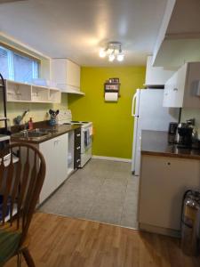cocina con nevera blanca y pared verde en L ' Arlequin Suite et logement, en Vaudreuil-Dorion