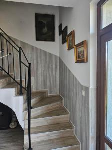 a staircase in a house with pictures on the wall at Бадевски рай- къща София in Veliko Tŭrnovo