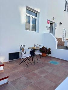 einen Tisch und Stühle in einem Zimmer mit einer Treppe in der Unterkunft Punta Garo in Punta de Mujeres