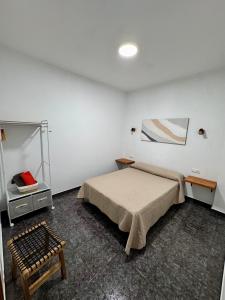 ein Schlafzimmer mit einem Bett und einem Spiegel in der Unterkunft Punta Garo in Punta de Mujeres