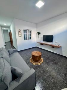 ein Wohnzimmer mit Couch und Flachbildfernseher in der Unterkunft Punta Garo in Punta de Mujeres