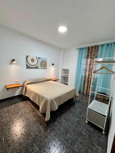 ein Schlafzimmer mit Bett, Schreibtisch und Fenster in der Unterkunft Punta Garo in Punta de Mujeres
